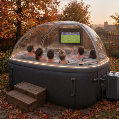 Rear view at golden hour — friends watching football on the TV inside the clear dome canopy